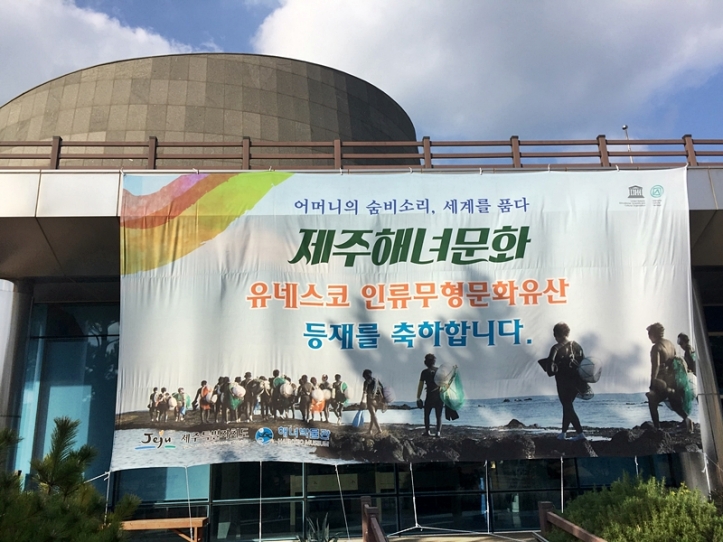 A banner outside the front of the Haenyeo Museum congratulating the UNESCO World Intangible Cultural Heritage status